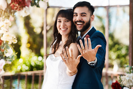 我们刚刚成为一对恩爱的年轻新婚夫妇 他们在婚礼当天站在户外闪耀着他们的结婚戒指图片