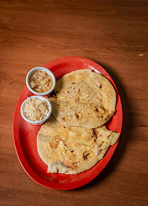 尼加拉瓜 pupusas 的特写镜头在木桌上供应 美味的传统萨尔瓦多 Pupusas 木桌上有融化的奶酪 在一张木桌上供应的传统图片