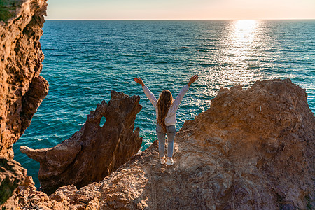 女游人 举手而立 天涯海角 见龙岩 女孩欢迎太阳 概念设计 一个成功的女人张开双臂看着夕阳全景火山动物旅游地标海岸线石头海岸蓝色背景图片