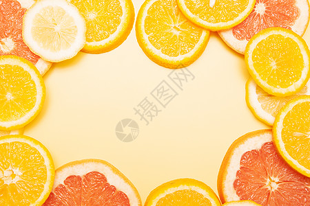 平面的橙子 葡萄油和柠檬片形成了黄底框 您文本中的淡色夏季柑橘成分很亮背景图片