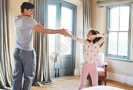 和爸爸一起练习她的舞蹈动作 一位父亲和他的小女儿在家里一起跳舞图片