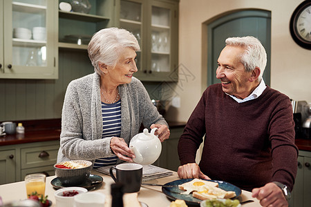 你是我最喜欢的一杯茶 一对深情的老年夫妇在家里的厨房里一起喝茶和吃饭图片