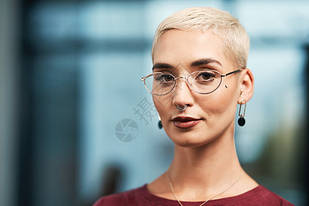 专注和以目标为驱动力的裁剪了一位有吸引力的年轻女商务人士的肖像 她戴着眼镜 独自站在办公室里图片