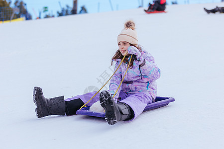 澳大利亚青年女孩Tobogganing雪橇衣服娱乐平底快乐假期手套孩子童年运动图片