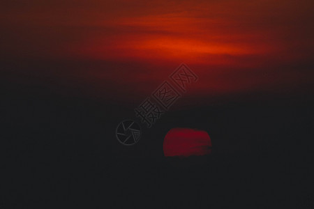 美丽的夕阳 太阳在日落时被云环绕 阳光照耀着振奋人心的橙色红云石头黄色风景红太阳红色地平线乌云天空橙子背景图片