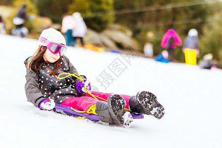 澳大利亚青年女孩Tobogganing快乐喜悦假期童年手套滑雪幸福微笑运动雪橇图片