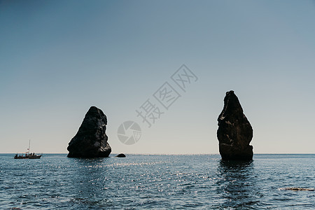 两块岩石在松绿海的中间从水中刺出 可见海洋视图 高质量照片 就像冰岛一样海岸天蓝色阳光快艇风景地方蓝色情调假期晴天图片