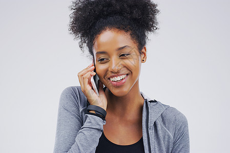 工作室拍到一位年轻女性在灰色背景下使用手机的镜头 她被拍到了电话黑发成人裁剪冒充技术姿势微笑女士图片