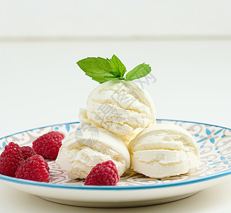 香草冰淇淋球和红莓果 在圆盘上奶制品覆盆子粉色绿色奶油状白色圆形食物盘子牛奶图片