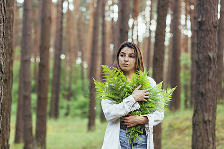 在树林里的女人拥抱着一束野生的花束 一个年轻的积极分子保护森林头发皮肤护理生态植物群青年青少年季节蕨类摄影图片