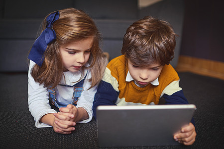 享受在任何地方 任何时间都可以从事的活动 一个小男孩和女孩在家里使用数字平板电脑图片