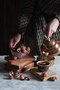 一个女人从铜茶壶里倒茶水 泡到杯子里 喝着莱奇和温柔的生活静物享受仪式女士古董爱好女性注意力桌子时间图片