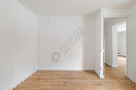 空荡荡的房间铺有复合地板 新粉刷的白墙位于经过翻新的公寓内 走廊通往其他房间 维修和施工概念建筑学压板硬木油漆房子地板地面住宅白图片
