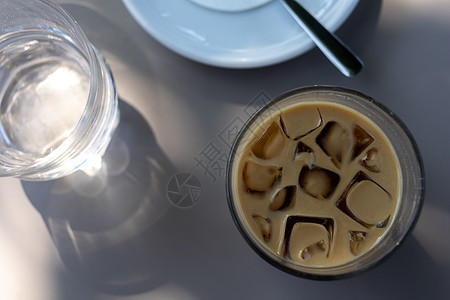 夏季露台桌边的冰咖啡杯冰块牛奶咖啡冰镇支撑饮料咖啡店阳台盘子飞碟背景