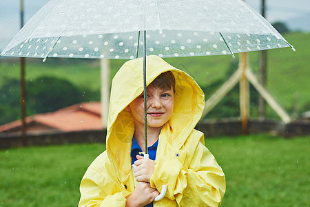 一个快乐的小男孩的肖像 站在雨天外面 拿着伞子站着 (笑声) (掌声)图片