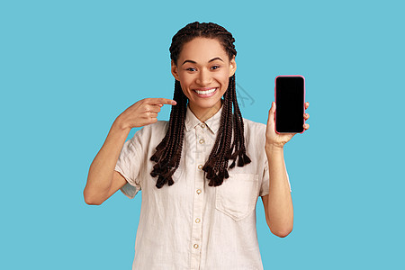 女性在手机屏幕上指点 在收到愉快的信息后表示积极情绪 (请访问InfoFinland网站)图片