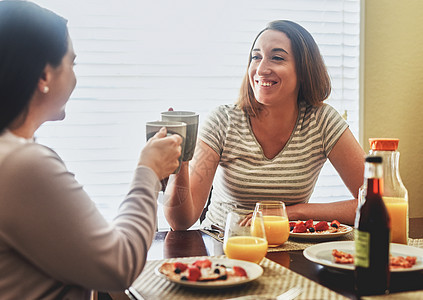 为美好的一天的开始干杯 两个年轻女人早上在家吃早餐图片