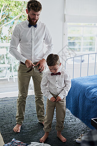 确保我们穿着完美 一个可爱的小男孩和他的父亲穿着相配的衣服图片