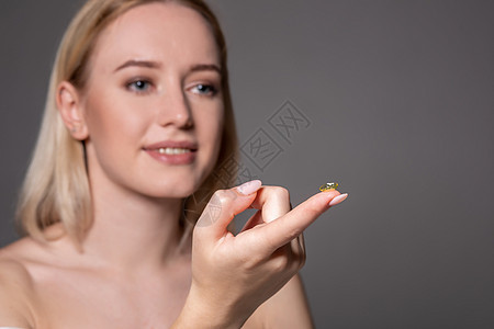 年轻女子在食指上拿着隐形眼镜 有复制空间 特写即将戴隐形眼镜的健康美丽女人的脸手指光学眼球微笑眼睛镜片眼科灰色眼镜女孩图片