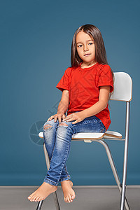 穿红色T短裤 坐在椅子上摆姿势的小女孩思考女性孩子微笑情绪婴儿童年t恤幼儿园乐趣图片