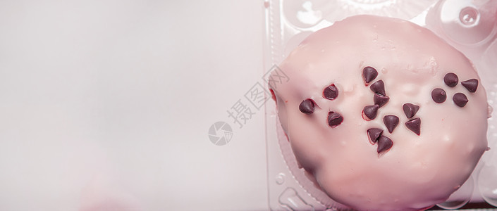 美味的甜甜圈 上面有糖霜和巧克力片 横幅上有左边空间的副本 粉红色图片
