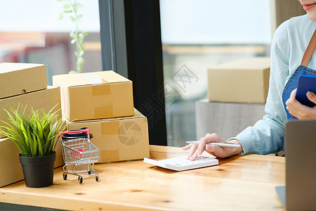 年轻的亚洲女商务人士在把包裹清单交给顾客之前 先核对邮包清单纸板工作命令技术运输贸易邮件职业商业船运图片