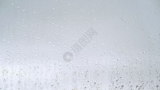 特写水滴落在玻璃上的视图 雨滴落在窗户上 雨季 秋天 雨滴滴落 灰色的天空压抑水分季节跑步沮丧天气下雨飞沫液体流动背景图片