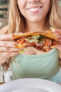 女孩吃着美味的墨西哥食品 玉米饼 沙司 糕点等等食物玉米桌子鳄梨牧师红色盘子绿色柠檬文化图片