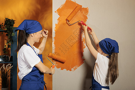 母亲和孩子用橙色的墙壁画背景图片