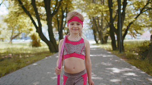 在城市清晨公园 与Hula hoop圆环一起行走的健身运动幼儿女孩图片