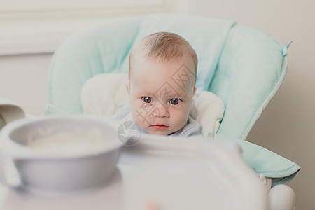 婴儿的第一个诱饵 婴儿食物 关于儿童营养的文章 笑声压痛早餐父母母亲窗户勺子母性女孩家庭围兜图片