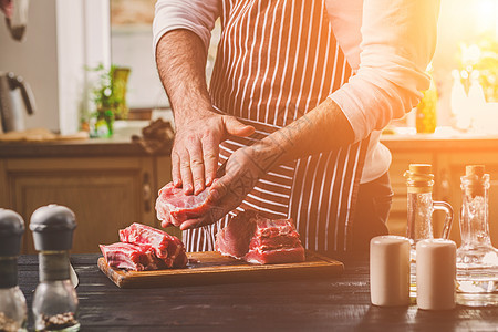 准备晚餐 肉类牛肉 里脊肉的烹饪 加工 男人的手腌肉撒上盐 胡椒食物烧烤木板男性牛扒柠檬美食香料桌子草药图片