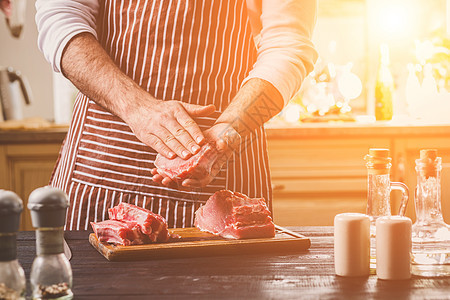 准备晚餐 肉类牛肉 里脊肉的烹饪 加工 男人的手腌肉撒上盐 胡椒草药牛扒烧烤香菜厨房食物桌子柠檬木板屠夫图片