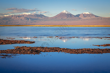 智利阿塔卡马沙漠日落时火山景观和盐湖反射天空地方盐滩风景反射草原目的地荒野普纳旅游图片