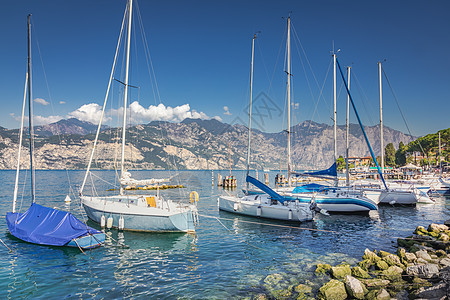 意大利北部马尔塞辛的加尔达海岸 带帆船游艇旅游文化蓝色海滩海岸线金色反射港口风景城市背景图片