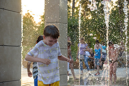 男孩们在喷泉中跳跃 孩子们在炎热的夏日玩城市喷泉 快乐的朋友在喷泉中玩得开心 夏天的天气 友谊 生活方式和假期运动男生孩子童年乐图片