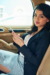 即使是在去办公室的路上 我也能检查一下 一个有吸引力的年轻女商务人士 在汽车里用手机图片
