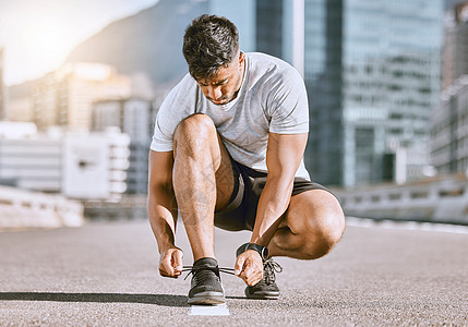 夏季 健康和健身跑步者在城市街道跑步前系鞋带 健康的男子运动员准备运动鞋 以便在运动锻炼 训练或马拉松锻炼时穿着舒适图片