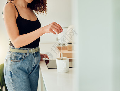 女人手拿凉茶袋放在一杯开水上 在厨房里做柴休息一下 在咖啡馆或咖啡店柜台工作的女咖啡师 在办公室午休期间喝热饮图片