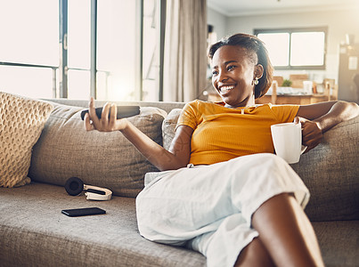 放松 无忧无虑 面带微笑的年轻女性在家里的客厅沙发上看电视和流媒体电影 坐在沙发上享受休闲时光的快乐 休闲和舒适的女人图片