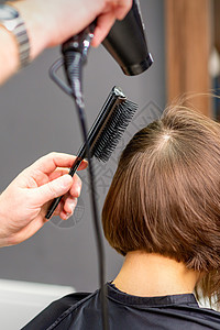 女人棕色头发的发丝干枯黑发烘干机烘干顾客工具成人梳妆台理发发型女性图片