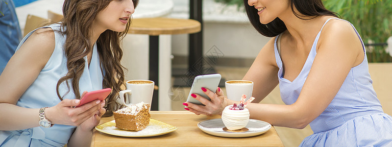 妇女通过电话看节目快乐食堂互联网咖啡店蛋糕商业姐妹女孩微笑朋友们图片