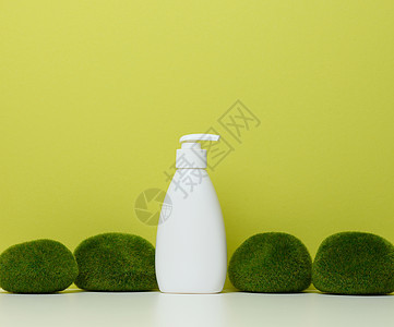 白色塑料瓶 在绿色背景上装有泵的白塑料瓶图片