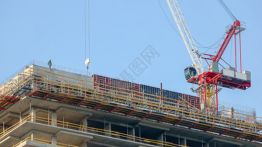 建筑工人和建筑工地的红色起重机图片