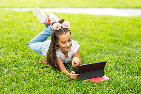免费教育 业余时间 技术和互联网概念     有平板电脑的小女孩青少年冲浪耳机药片闲暇阅读学校青春期上网女孩图片