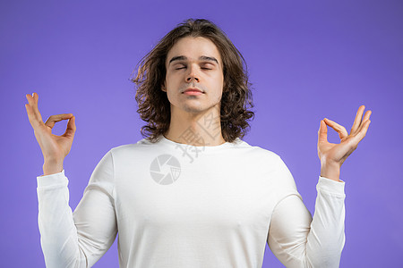 穿着基本 T 恤的冷静男人放松 冥想 他平静下来 在紫罗兰工作室背景下用 mudra om 深呼吸 瑜伽概念训练练习成人闲暇女孩图片
