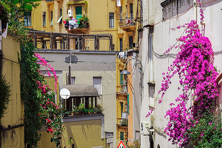 意大利那不勒斯的墙上有阳台和布恩加维拉的建筑物图片