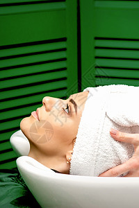 理发师把客户的头发弄湿了洗发水女士造型师沙龙治疗工作室服务女性工作毛巾图片