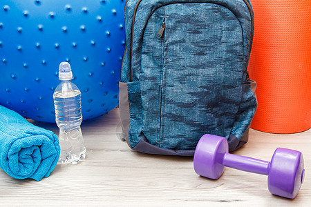 会议室地板健身用的各种背包和不同工具重量毛巾运动员体操运动哑铃力量训练白色瓶子图片
