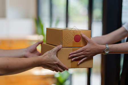 亚洲女雇员自由职业者 带包裹箱送到客户的亚洲女雇员产品店铺公司商业纸板包装存货船运成功购物图片